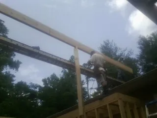 Carpenter setting a ridge beam over a new addition frame — Ice Dam Removal by Roofing Brothers in Oriskany Falls