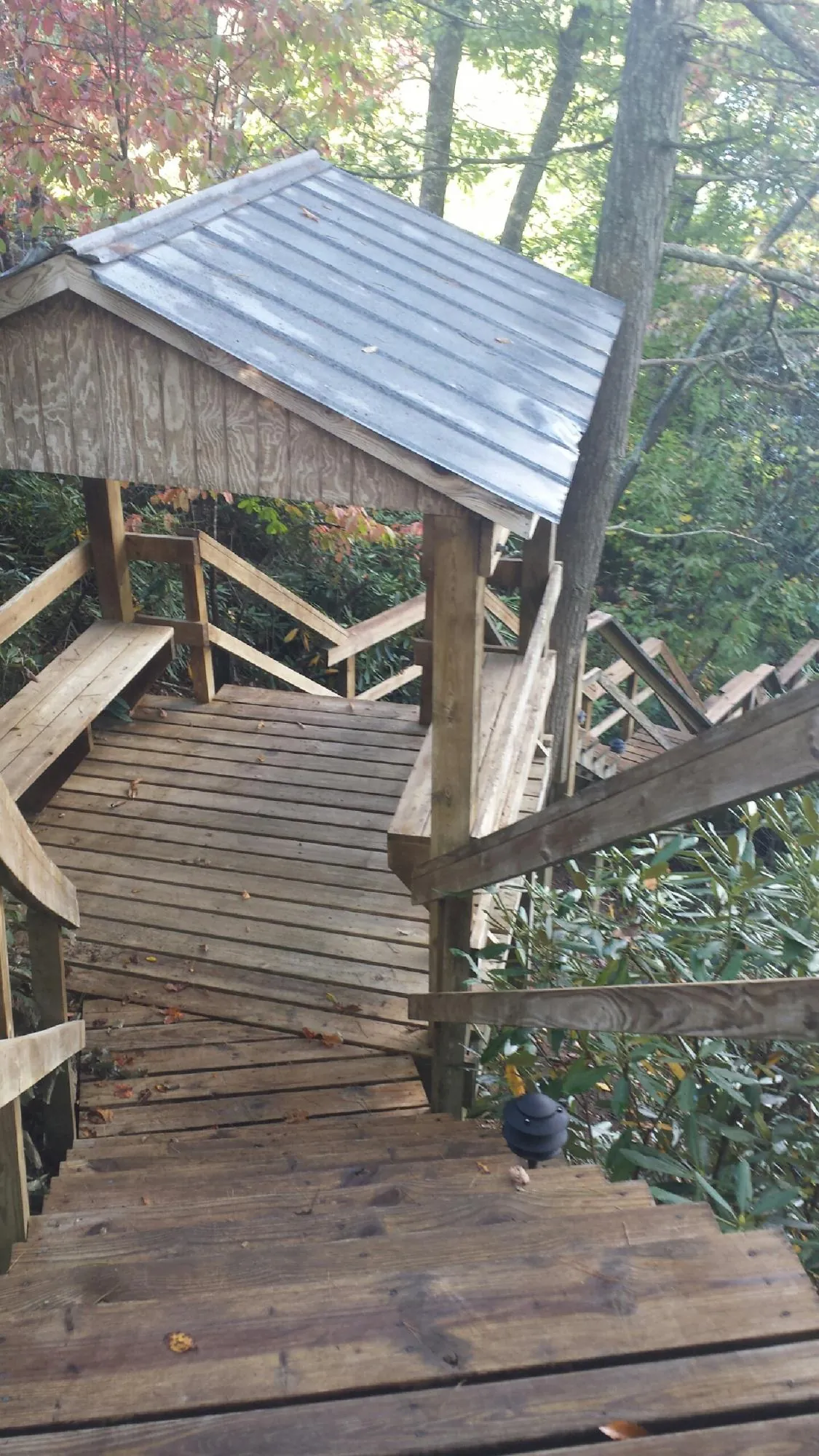 Metal roofed shelter over wooden steps on a wooded walkway — Skylight Repair & Installation work by our crew in Oriskany Falls