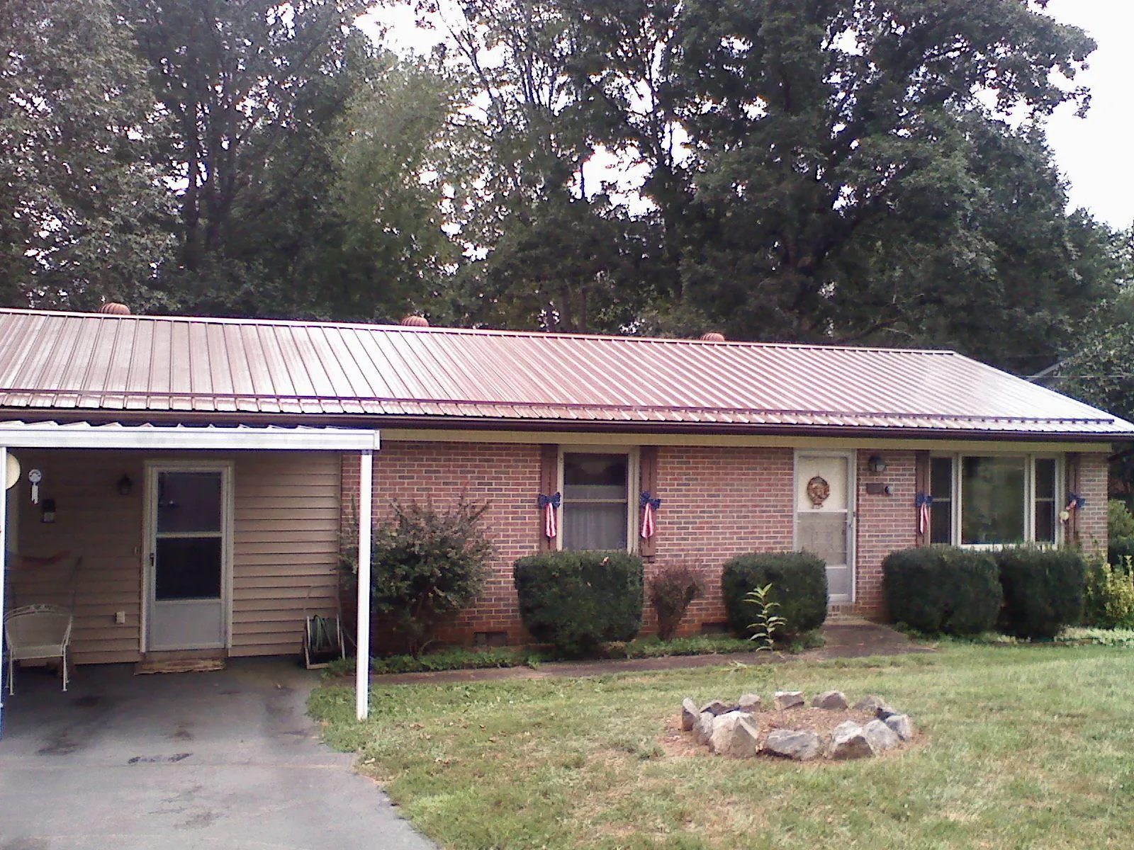 Bronze metal roof and carport on a brick ranch home — Roof Repair work by our crew in Oriskany Falls